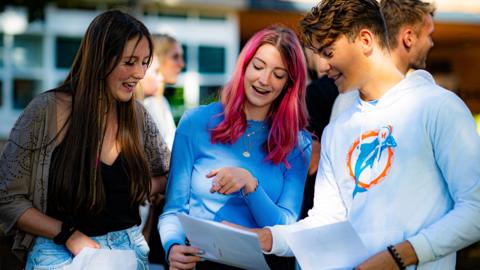 Students react as they share their results with their friends at Taunton School in Somerset, as students receive their A-Level results