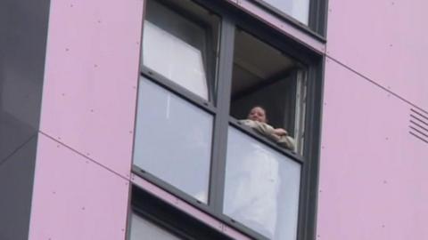 Woman in tower block window