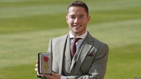 Alfie Hewett holding an OBE medal