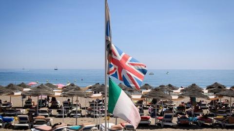 British flag flying above a beach in Spain