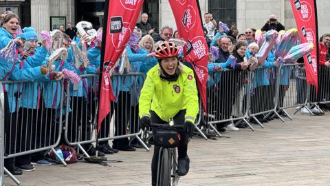 Mollie King cycles into Queen Victoria Square