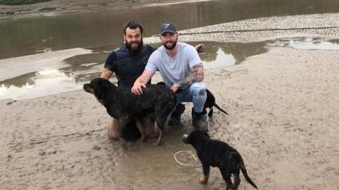 Jonathan Powell and Sean Lomas with Bella the dog, who the pair saved from estuary mud in Gloucestershire