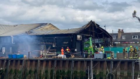 The wreckage of a burnt out commercial building in Whitstable Harbour