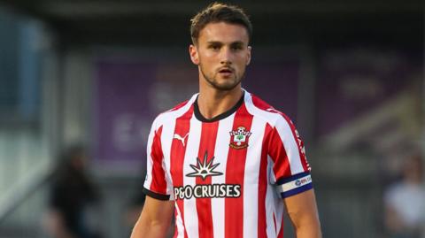 Taylor Harwood-Bellis in action for Southampton wearing a red and white shirt