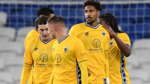 Aron Sasu of Wimbledon celebrates scoring a goal with team mates