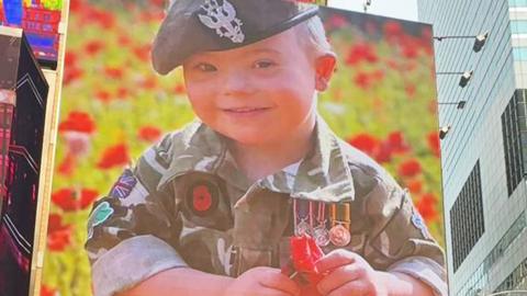 Photo of Ethan on Times Square screen wearing a military uniform
