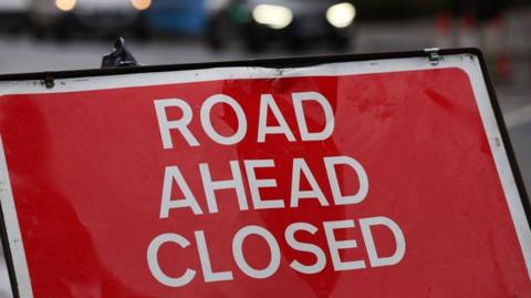 A road sign reads 'Road ahead closed.