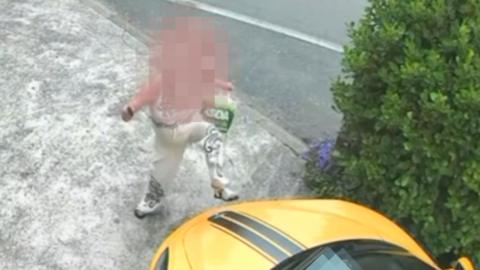 CCTV of woman kicking a yellow McLaren