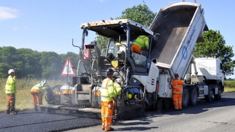 Workmen gritting a road