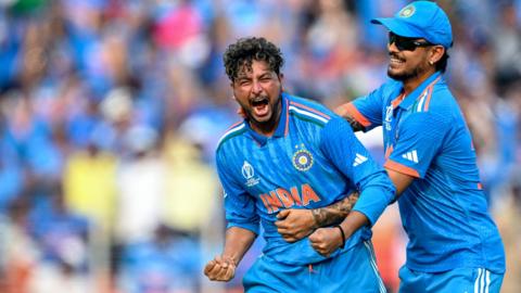 India's Kuldeep Yadav (L) celebrates with teammate Ishan Kishan after taking the wicket of Pakistan's Saud Shakeel