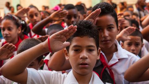 Cuban schoolchildren salute as they cry out loud the slogan 'Pioneers for Communism, we will be like Che!' on the first day of the 2013-2014 academic year, in Havana on September 2, 2013.