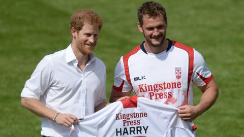 Prince Harry (left) is presented with a rugby league shirt by Sean O'Loughlin (right)