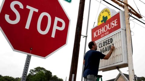 Bar owner Petros Markantonis changes the marquee outside his bar to "Closed Again" at the West Alabama Ice House in Houston, Texas, 26 June 2020