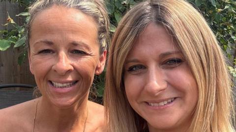 Two women smile to camera