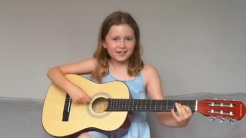 Girl playing guitar for song