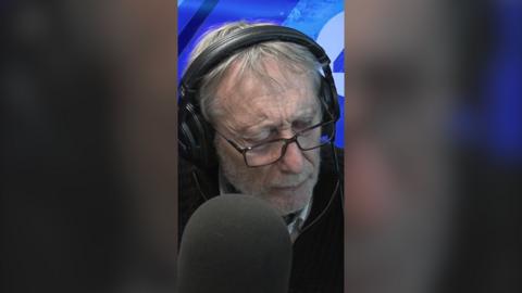 Michael Rosen speaking into a microphone at a BBC studio
