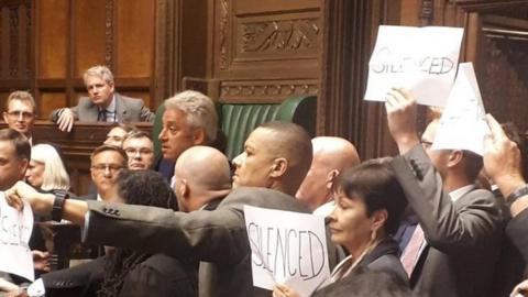 MPs protest around the Speaker's chair