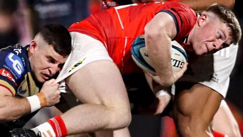 Patrick Campbell of Munster is tackled by Dane Blacker of Scarlets