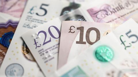 Stock image of money - a £5 note, a £20 note, a £10 note and another £5 note.