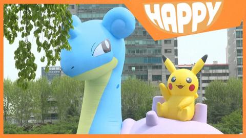 two gian pokemon balloons and the Happy News logo
