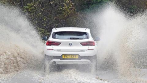 A car driving through floodwater