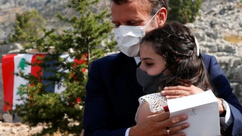 French President Emmanuel Macron hugs a victim of the Beirut blast after planting a cedar tree in Jaj, Lebanon (1 September 2020)