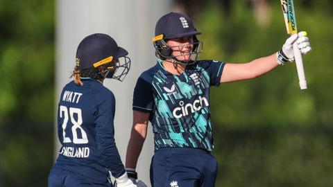 Nat Sciver raising her bat to celebrate a half-century v West Indies