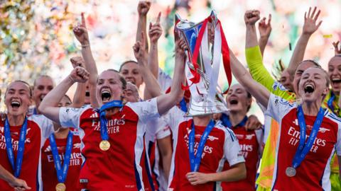 Arsenal players lift the Champions League trophy