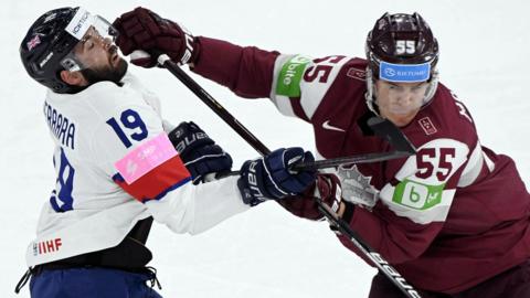 Great Britain's Luke Ferrara and Latvia's Roberts Mamcics in action at the Ice Hockey World Championship