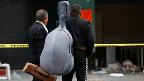 Mariachi musicians observe a crime scene hours after unknown assailants attacked people with rifles and pistols at an intersection on the edge of the tourist Plaza Garibaldi in Mexico City, Mexico September 15, 2018