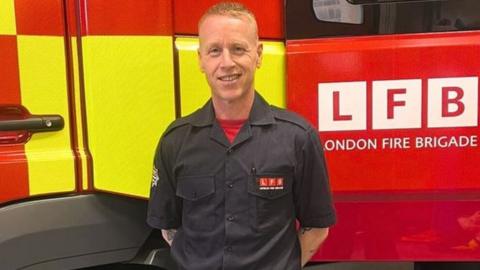 Steve Moore in front of a London Fire Brigade truck
