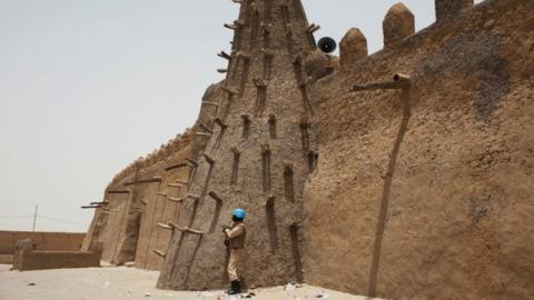 A UN peacekeeper from Burkina Faso stands guard at the 14th Century Djinguereber mosque in Timbuktu, Mali