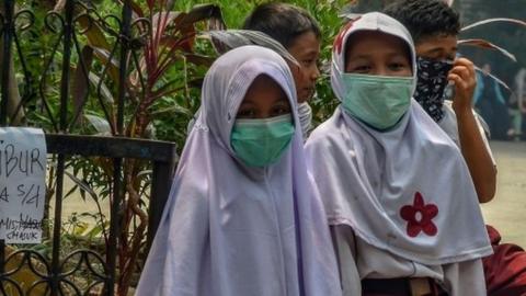 Indonesian schoolgirls wear facemasks