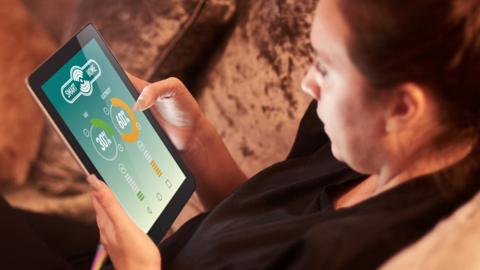 A woman reads a smart meter on a tablet