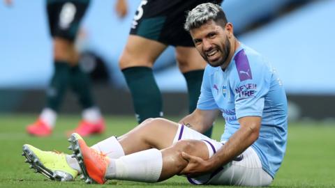 Manchester City striker Sergio Aguero appears in pain as he sits up after injuring his knee against Burnley in June