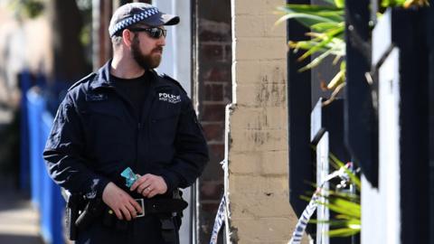 An officer conducts a counter-terrorism raid in Sydney, 1 August 2017