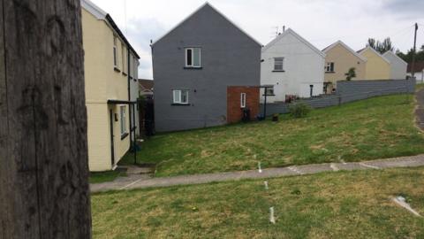 White markings on grass outside homes on Heol Scwrfa