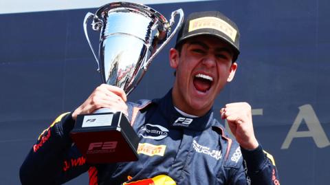 Arvid Lindblad celebrates with the trophy after winning the sprint race at the Bahrain Grand Prix