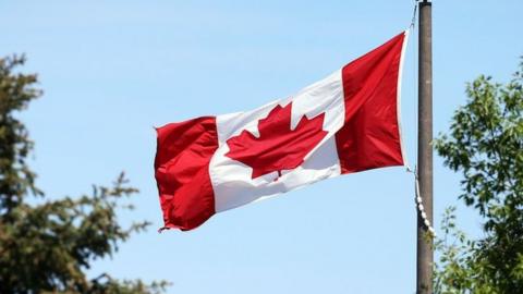 A Canadian flag flies in the breeze