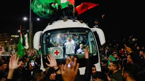 People gather around a bus to celebrate the return of Palestinian prisoners.
