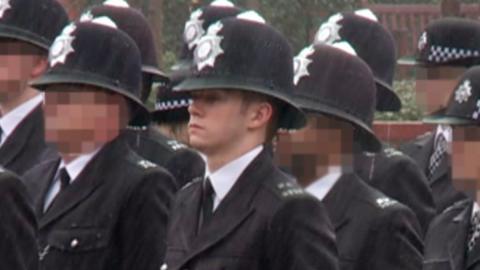 Still from footage of Ben Hannam in police uniform
