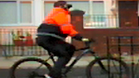 cyclist in orange jacket