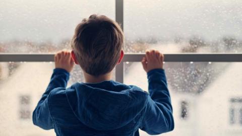 Stock image of a boy at a window