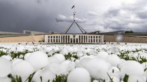 Giant hail covers the lawn outside Parliament House in Canberra