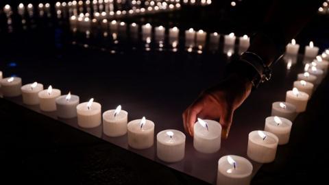 A hand placing candles during Earth hour