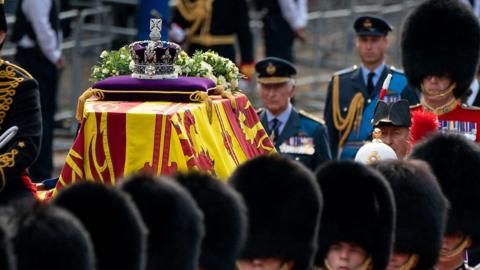 King Charles III walks behind Queen Elizabeth II's coffin