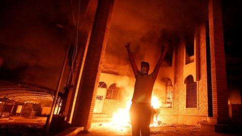 Iraqi protesters are seen near the burnt Iranian Consulate in Basra, 7 September 2018