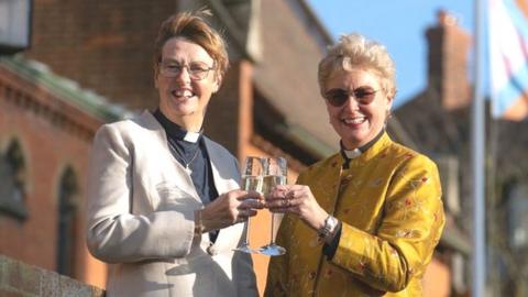 Catherine Bond (left) and Jane Pearce toasting after their blessing at St John the Baptist church in Felixstowe, Suffolk