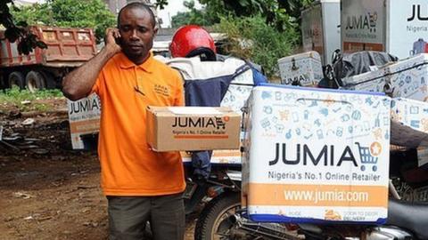 A Jumia scooterman tries to speak to clients to be delivered with product at the Ikeja warehouse of the company in lagos on June 12, 2013.