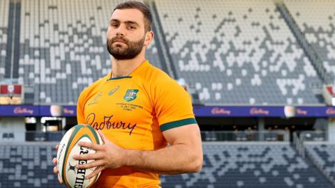 Josh Kemeny posing for a photo in his Wallabies shirt